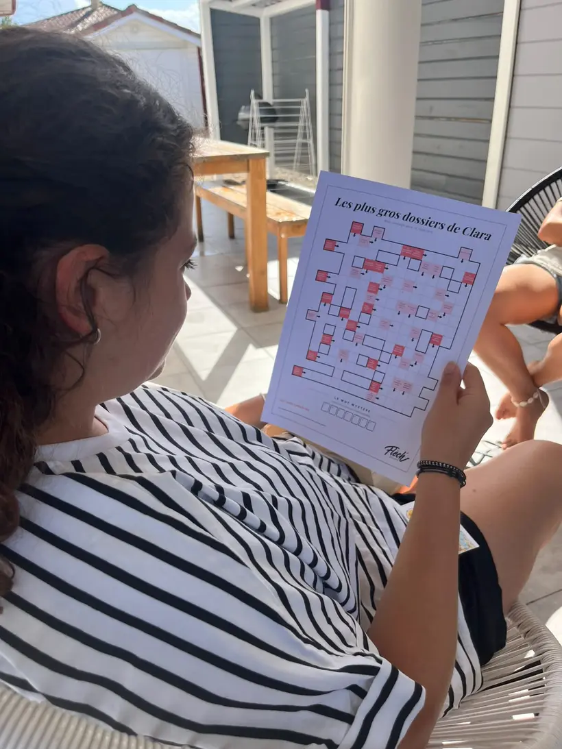 Une amie qui lit sa grille Flèch' sur une terrasse